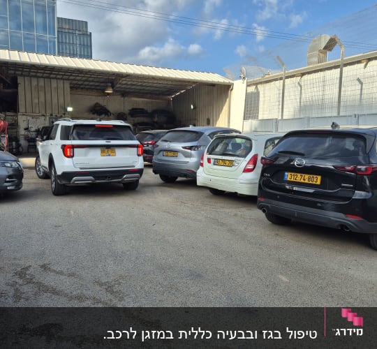 מכוניות חונות ליד מוסך עם ציוד חשמלי לרכב